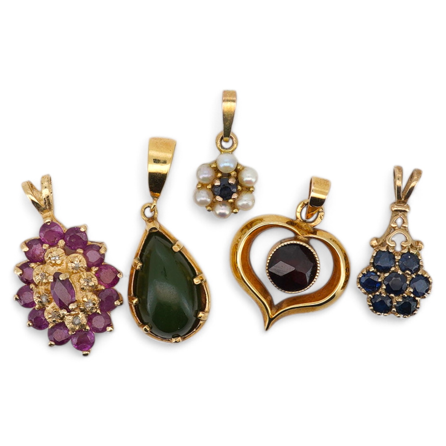 A modern 9ct gold and pear shaped nephrite set pendant, overall 25mm, a similar 9ct gold and garnet set pendant and three other gem set pendants, including 9ct and two unmarked. Condition - fair to good